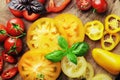 Composition of fresh ripe tomatoes of different varieties, spices, basil, rosemary, thyme, hot pepper on a wooden board Royalty Free Stock Photo