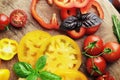 Composition of fresh ripe tomatoes of different varieties, spices, basil, rosemary, thyme, hot pepper on a wooden board Royalty Free Stock Photo