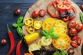 Composition of fresh ripe tomatoes of different varieties, spices, basil, rosemary, thyme, hot pepper on a wooden board isolated o Royalty Free Stock Photo