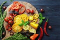 Composition of fresh ripe tomatoes of different varieties, spices, basil, rosemary, thyme, hot pepper on a wooden board isolated o Royalty Free Stock Photo