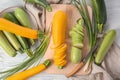 Composition with fresh zucchinis on white wooden table