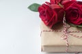 Composition of gift and bouquet of red roses on white background . Happy Valentines Day. Top view. Space for text Royalty Free Stock Photo