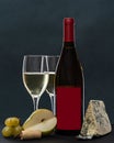 Composition with glass and bottle of white wine with blue mold cheese, pear and grapes on grey background. copy space Royalty Free Stock Photo