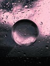 composition of glass,circle and water drops in pink color