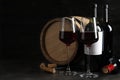 Composition with glasses and bottles of red wine on table against dark background Royalty Free Stock Photo