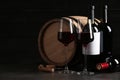 Composition with glasses and bottles of red wine on table against dark background Royalty Free Stock Photo