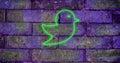 Composition of green neon bird icon on brick wall Royalty Free Stock Photo