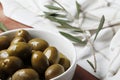 Composition of green olives and bottles of olive oil on the background.