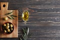 Composition of green olives, olive oil, on a wooden background