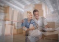 Composition of happy couple unpacking in new home over stacks of cardboard boxes in warehouse Royalty Free Stock Photo