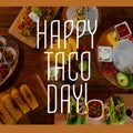 Composition of happy taco day text with tacos on table Royalty Free Stock Photo