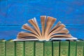 Composition with hardback books, fanned pages on wooden deck table and blue background. Books stacking. Back to school. Copy Space Royalty Free Stock Photo