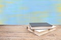 Composition with hardback books, fanned pages on wooden deck table and blue background. Books stacking. Back to school. Copy Space Royalty Free Stock Photo