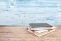 Composition with hardback books, fanned pages on wooden deck table and blue background. Books stacking. Back to school. Copy Space Royalty Free Stock Photo