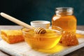 Composition honeycombs, honey, jars and dipper on gray table