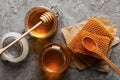 Composition honeycombs, honey and jars on gray background