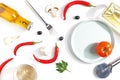 Composition of hot red pepper, oil, a bottle of white wine, slices of cheese and mushrooms on a white background. Top view