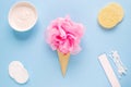 Composition of ice cream cone with pink wisp of bast on a light blue background