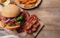 Composition with juicy bacon burger on table, above view. Space for text Royalty Free Stock Photo