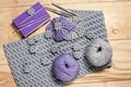 Composition of knitting accessories and needlework elements. Grey and purple napkins, balls of wool yarn, book, hooks on light Royalty Free Stock Photo