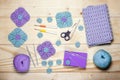 Composition of knitting accessories. Purple crocheted square napkins, balls of wool yarn, scissors, crochet hooks on light Royalty Free Stock Photo