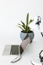 Composition with laptop on white tabletop with glasses, desklamp