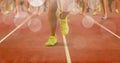 Composition of legs of running male athletes on racing track with spots of light