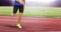 Composition of low section of male athlete running on track in sports stadium Royalty Free Stock Photo