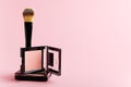 Composition with makeup items on a white background. Black brush, makeup tool, packing of blush and powder on a pastel backdrop. Royalty Free Stock Photo