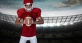 Composition of male american football player holding ball over sports stadium Royalty Free Stock Photo