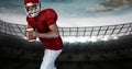 Composition of male american football player holding ball over sports stadium Royalty Free Stock Photo