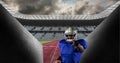 Composition of male american football player holding ball over sports stadium Royalty Free Stock Photo