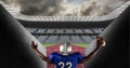 Composition of male american football player holding ball and raising hands over sports stadium Royalty Free Stock Photo