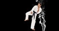 Composition of male martial karate artist with black belt kicking over smoke and copy space Royalty Free Stock Photo