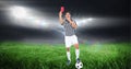 Composition of male referee with football holding red card at football stadium