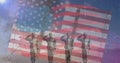 Composition of male soldiers silhouette saluting over american flag Royalty Free Stock Photo