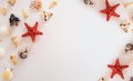 Composition of many white, beige, black exotic seashells different shapes and types and red starfish on a white background. Summer Royalty Free Stock Photo