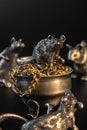Composition from metal figures: rats are fighting for a gold. Products from silver and gold. The concept of the zodiac calendar in