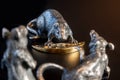 Composition from metal figures: rats are fighting for a piece of cheese. Products from silver and gold. The concept of the zodiac