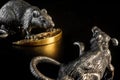 Composition from metal figures: rats are fighting for a piece of cheese. Products from silver and gold. The concept of the zodiac