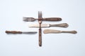 Composition of metal vintage knives with an ornament and old forks with wooden handles on a gray background with space Royalty Free Stock Photo