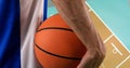 Composition of midsection of male basketball player with ball over basketball court