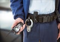 Composition of midsection of male security guard holding walkie talkie over blurred background