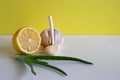 Composition with natural cold remedies on a white table on a yellow background. Garlic, lemon, aloe folk remedies Royalty Free Stock Photo