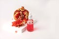 Composition with natural cosmetic oil and pomegranate on light background.