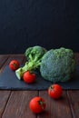 A natural vegetables broccoli and tomatoes lies on a wooden table