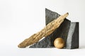 Composition with nature elements - stones, golden sphere and wooden log on white background