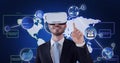 Composition of network of icons with world map over man wearing vr headset touching screen