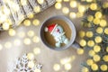 Composition of the new year yellow bokeh  a gray mug with coffee marshmallows in the form of a snowman in a red hat Royalty Free Stock Photo