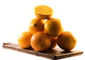 Composition of nicely colored oranges on a white background - front and back and cut in half on a wooden board